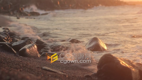 黄昏金黄色的落日余晖下海浪冲刷在海边的岩石上实拍视频素材
